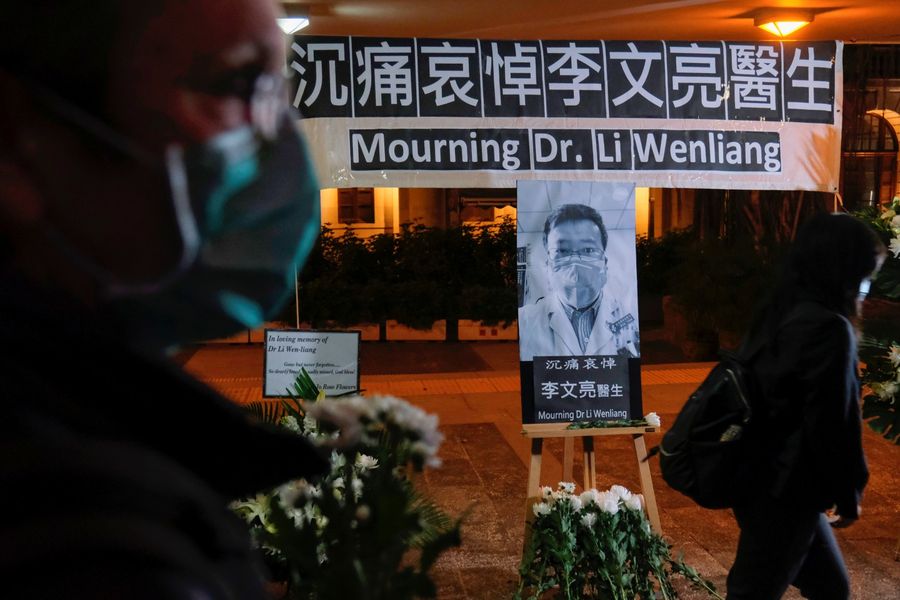 In this photo taken on 7 February 2020, people wearing masks attend a vigil in Hong Kong for late Dr Li Wenliang, an ophthalmologist who died of Covid-19 at a hospital in Wuhan. (Tyrone Siu/Reuters)