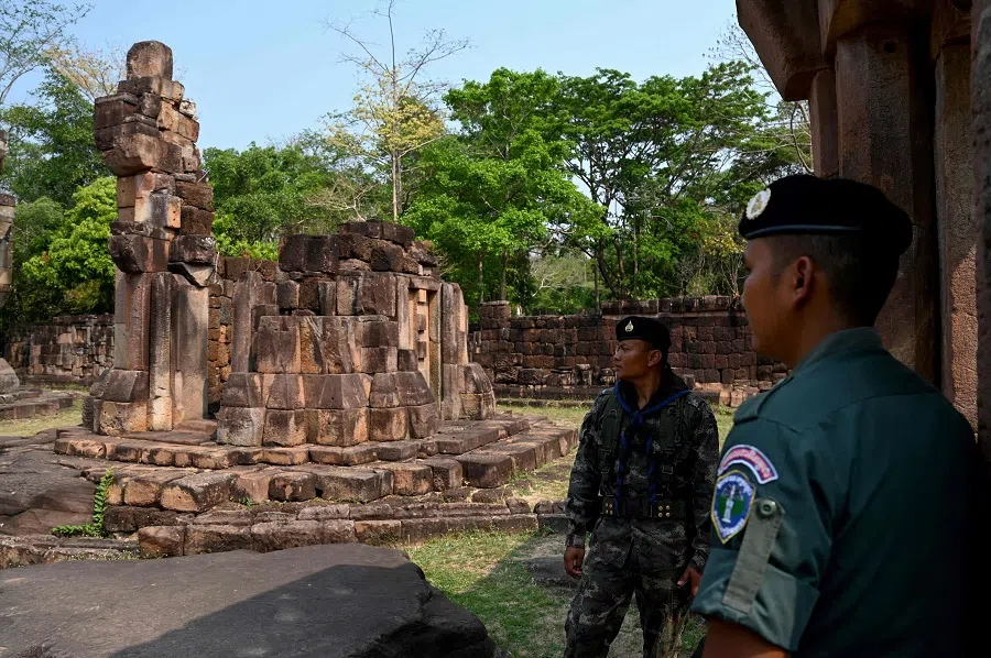 A Cambodian soldier (right) and Thai soldier stand guard at the disputed ancient Khmer temple Prasat Ta Muen Thom, or Prasat Ta Moan Thom in Khmer, on the Cambodian-Thai border in Oddar Meanchey province on 26 March 2025. (Tang Chhin Sothy/AFP)