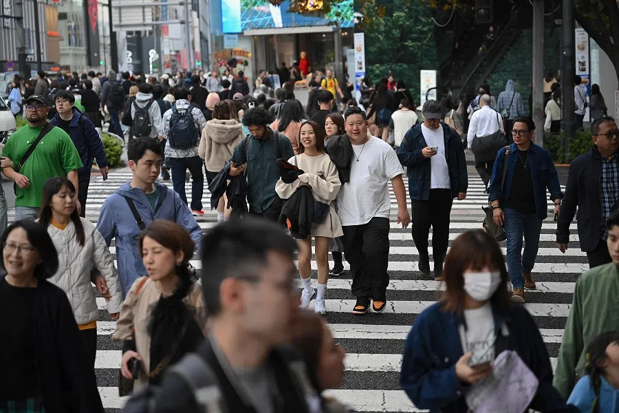 People cross a street in the Omotesando shopping area in Tokyo on 15 November 2024. (Yuichi Yamazaki/AFP)