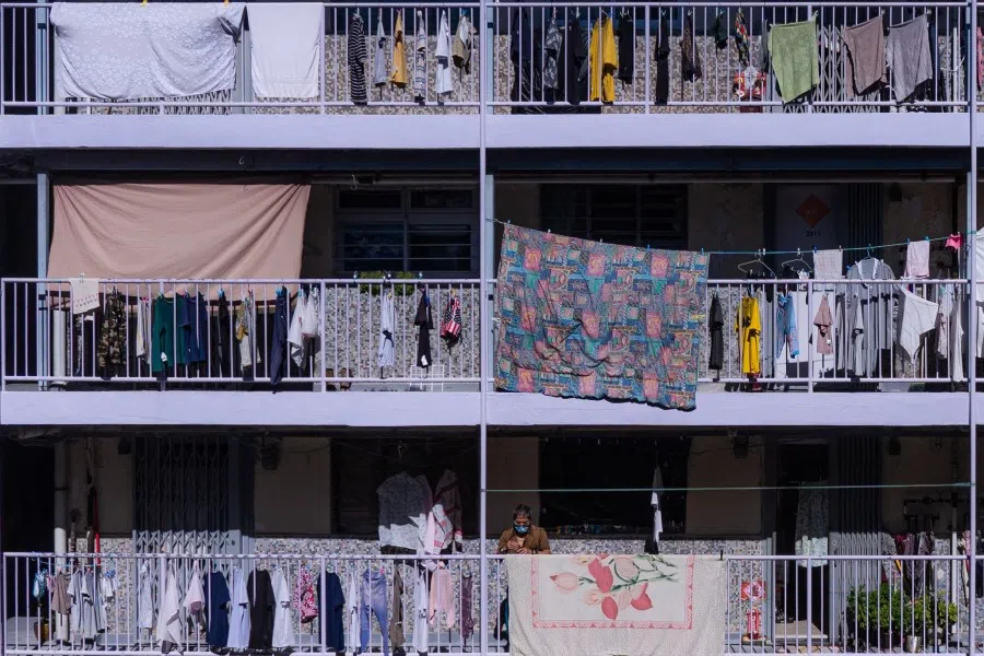 A man hangs a blanket at a public estate in Hong Kong on 4 September 2021. (Bertha Wang/AFP)