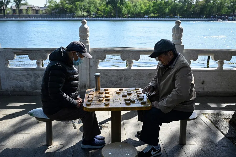 Two elderly men play Chinese chess at a park in Beijing on 25 April 2023. (Jade Gao/AFP)