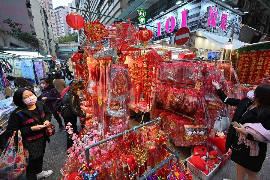 People look at lunar new year decorations on sale at a market in Hong Kong on 13 January 2022. (Peter Parks/AFP)