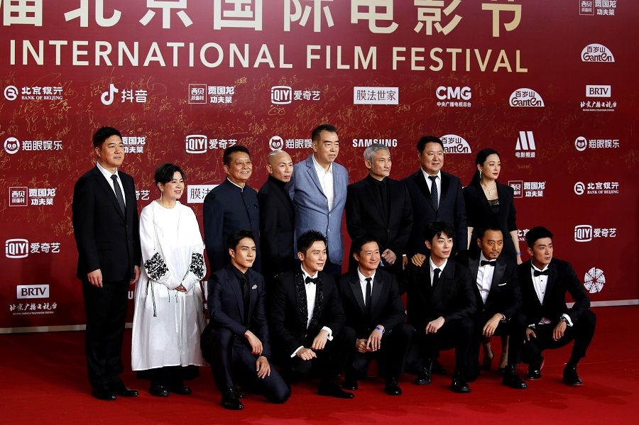 Directors Chen Kaige, Dante Lam and Tsui Hark pose for photos with crew members of the film The Battle at Lake Changjin, during a red carpet ceremony at the Beijing International Film Festival, in Beijing, China, 20 September 2021. (Tingshu Wang/File Photo/Reuters)