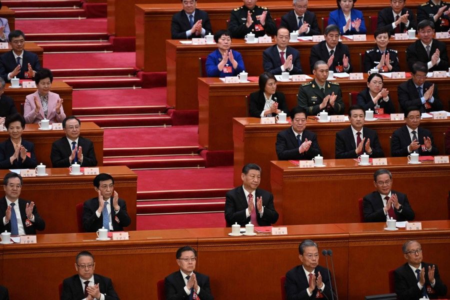 China's President Xi Jinping (centre) applauds the results of the final vote during the closing session of the 14th National People's Congress (NPC) at the Great Hall of the People in Beijing on 11 March 2024. (Greg Baker/AFP)