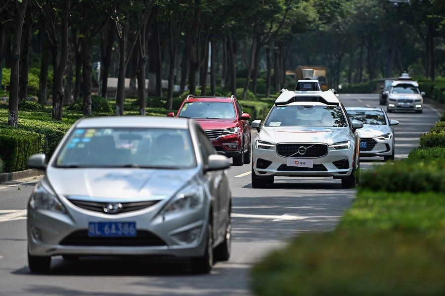 This photo taken on 22 July 2020 shows a Didi Chuxing autonomous taxi (centre) during a pilot test drive on the streets of Shanghai. (Hector Retamal/AFP)