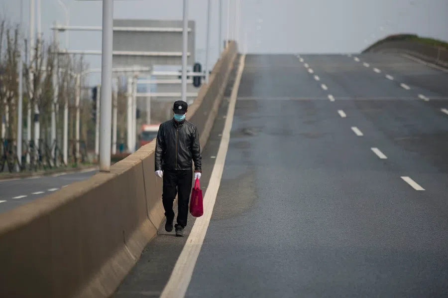 A man walks on an empty street in Wuhan, China, on 29 February 2020. (STR/AFP)