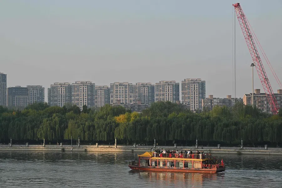 People ride on a boat along the grand canal in Beijing, China on 11 October 2024.