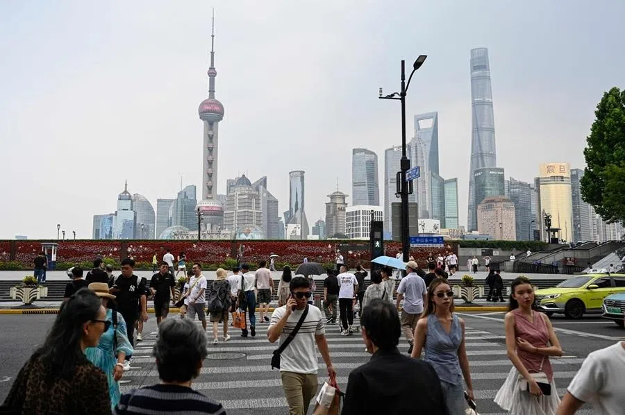 People cross the street near the Bund in Shanghai on 2 June 2026.