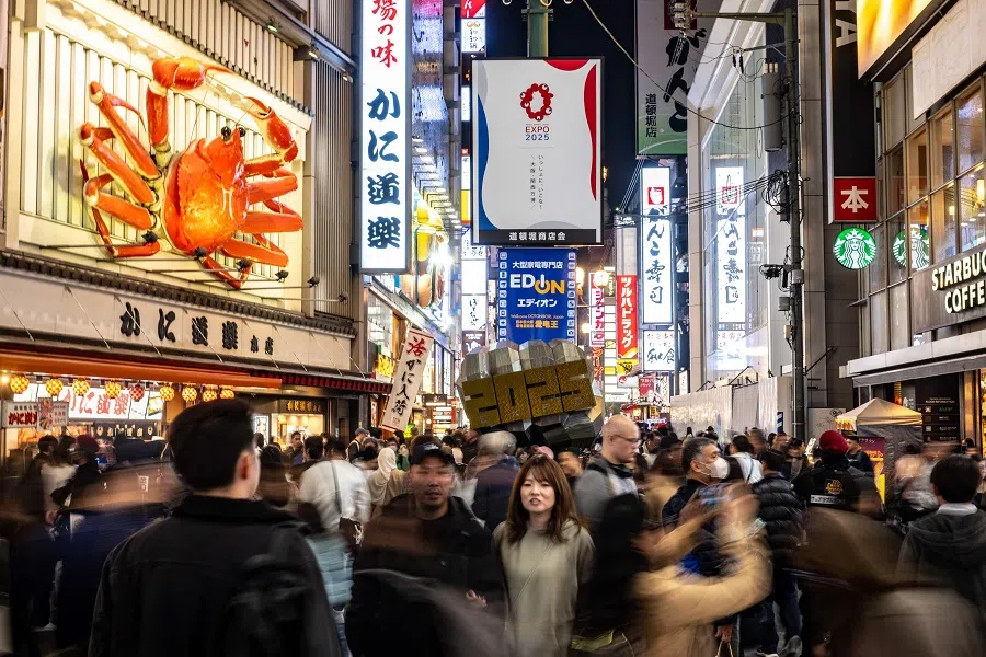 People walk along a street in Osaka's Dotonbori district, Japan, on 23 November 2023. (Philip Fong/AFP)