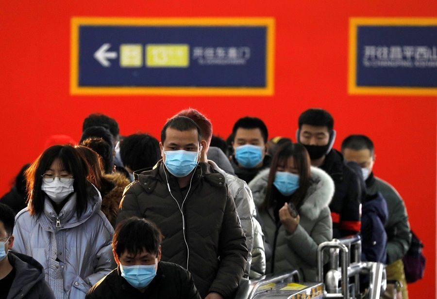 People wearing face masks commute in a subway station during morning rush hour in Beijing, China, 20 January 2021. (Tingshu Wang/Reuters)