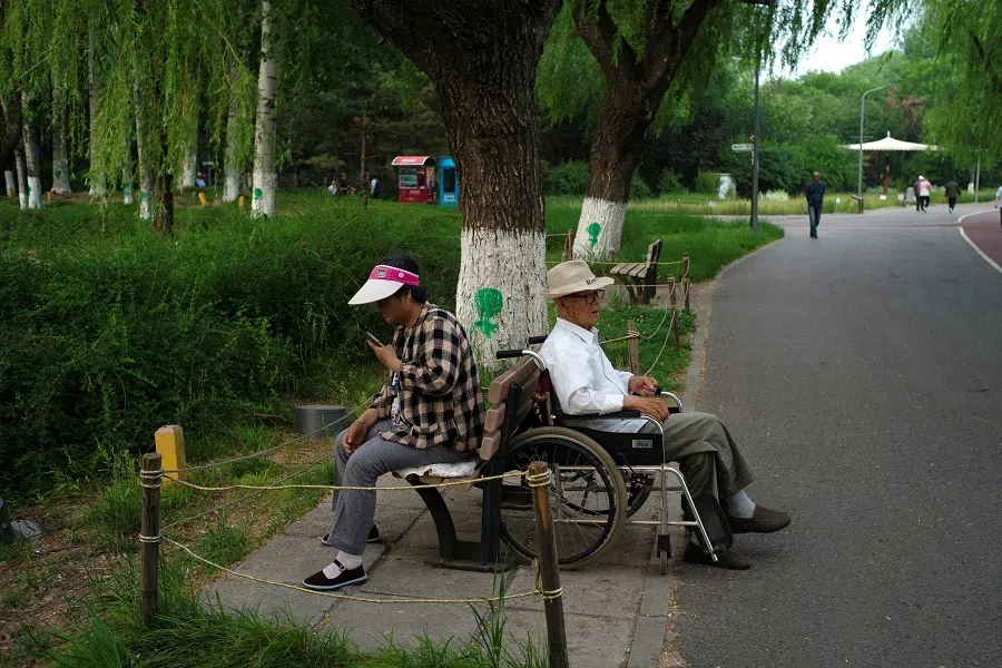 Elderly people rest at a park in Beijing, China, on 22 May 2024. (Tingshu Wang/Reuters)
