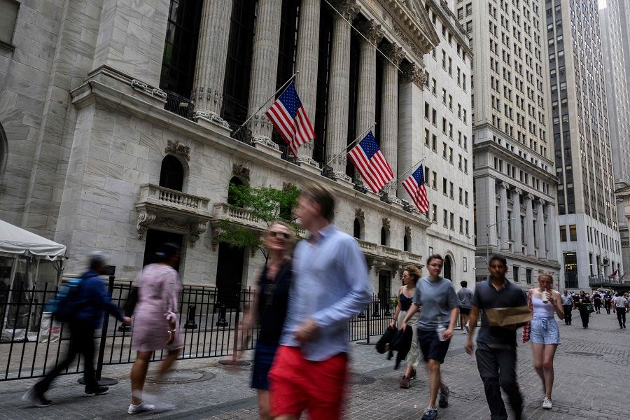 In this file photo taken on 12 July 2022, people walk past the New York Stock Exchange (NYSE) on Wall Street in New York City, US. (Angela Weiss/AFP)