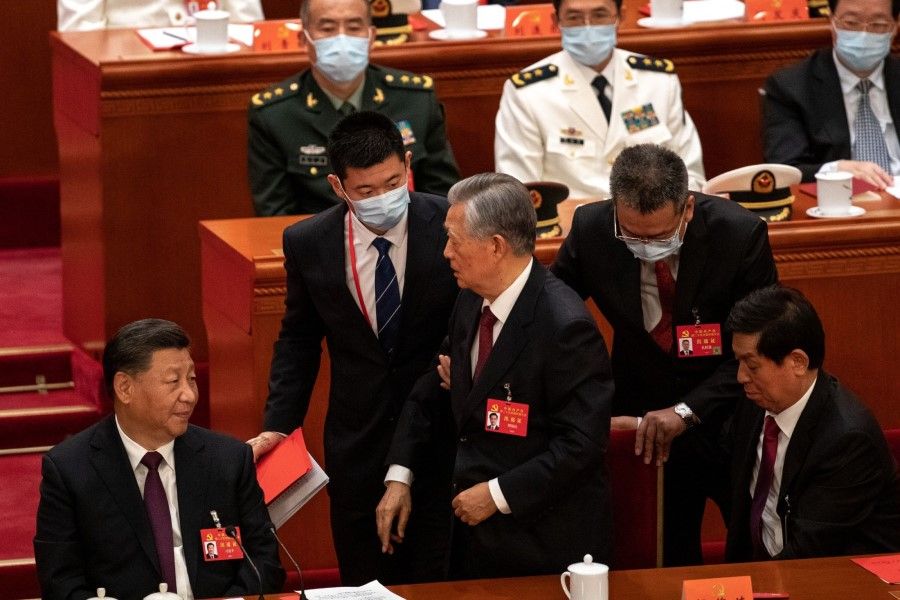 Hu Jintao, China's former president, is escorted out of the closing session of the 20th Party Congress of the Chinese Communist Party at the Great Hall of the People in Beijing, China, on 22 October 2022. (Bloomberg)