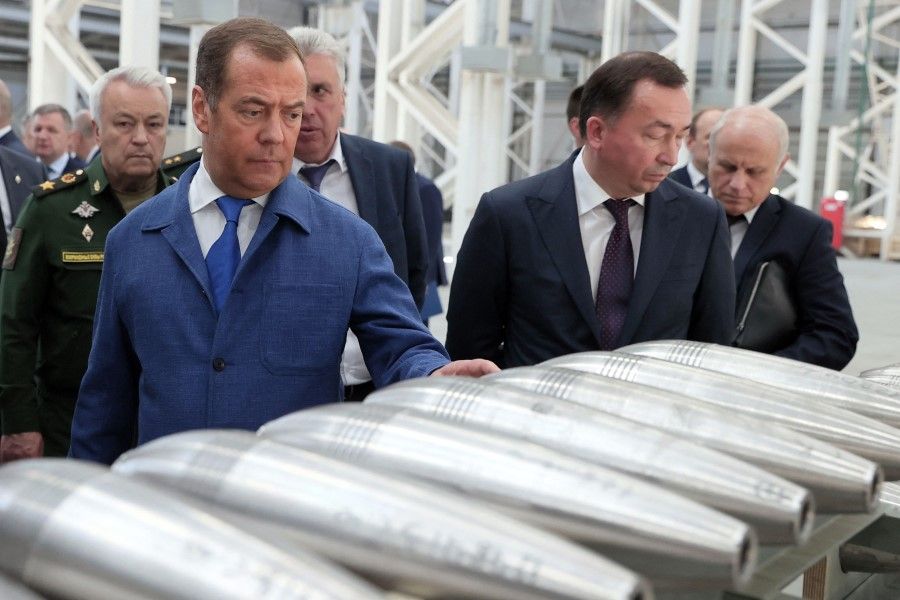 Russia's former leader Dmitry Medvedev (left, in blue suit), deputy chairman of Russia's security council, visits the Aleksin Experimental Mechanical Plant in the Tula region of Russia on 15 June 2023. (Yekaterina Shtukina/Sputnik/AFP)