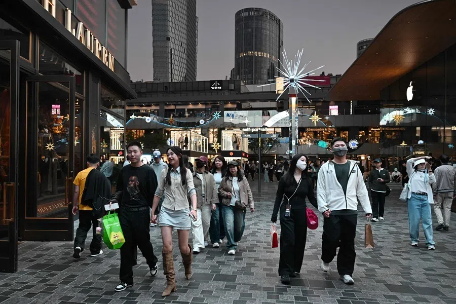 People walk through a shopping mall on the last day of a seven-day National Day holiday in Beijing on 7 October 2026.