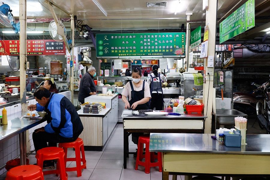 People eat breakfast at a morning market in Chiayi, Taiwan, 31 March 2023. (Ann Wang/Reuters)
