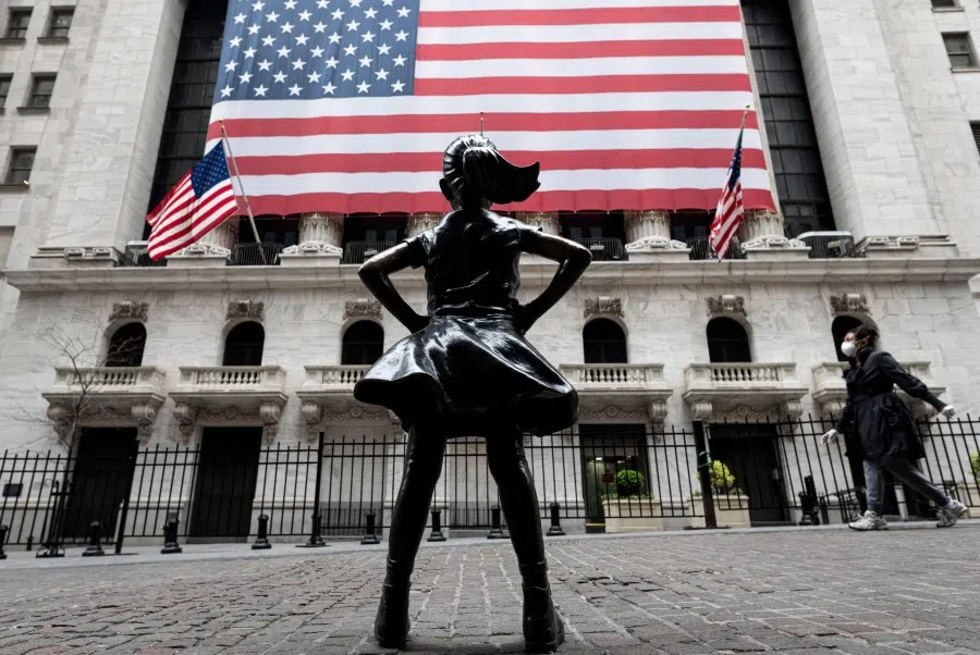 The fearless girl statue and the New York Stock Exchange (NYSE) are pictured on 20 April 2020 at Wall Street in New York City. (Johannes Eisele/AFP)