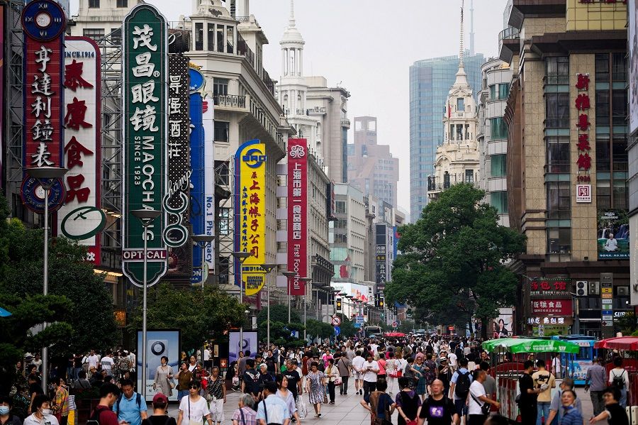 People walk along Nanjing Road, a main shopping area, in Shanghai, China, on 26 September 2023. (Aly Song/Reuters)