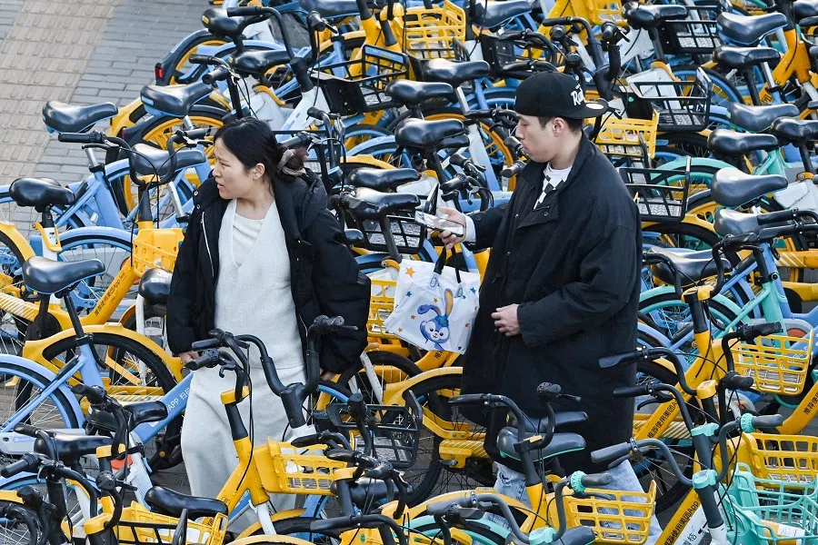 A man walks among shared bicycles in Beijing on 30 November 2024. (Adek Berry/AFP)