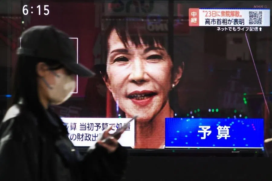 A woman walks past a television screen showing Japan’s Prime Minister Sanae Takaichi’s press conference in Tokyo on 19 January 2026. (Kazuhiro Nogi/AFP)