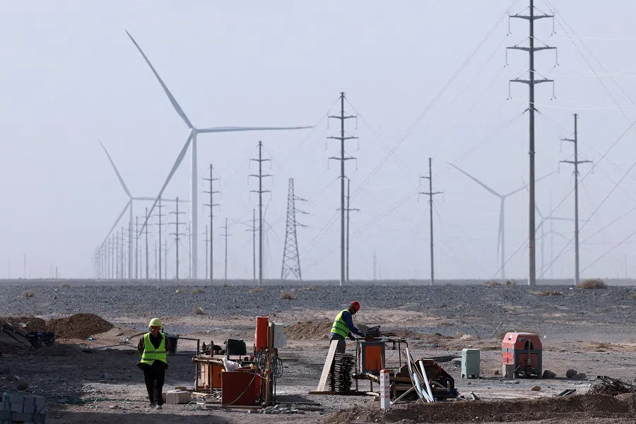 Workers work at a construction site at a Taiyuan New Energy Co. wind farm, during an organised media tour in Jiuquan, Gansu province, China, on 17 October 2024. (Tingshu Wang/Reuters)