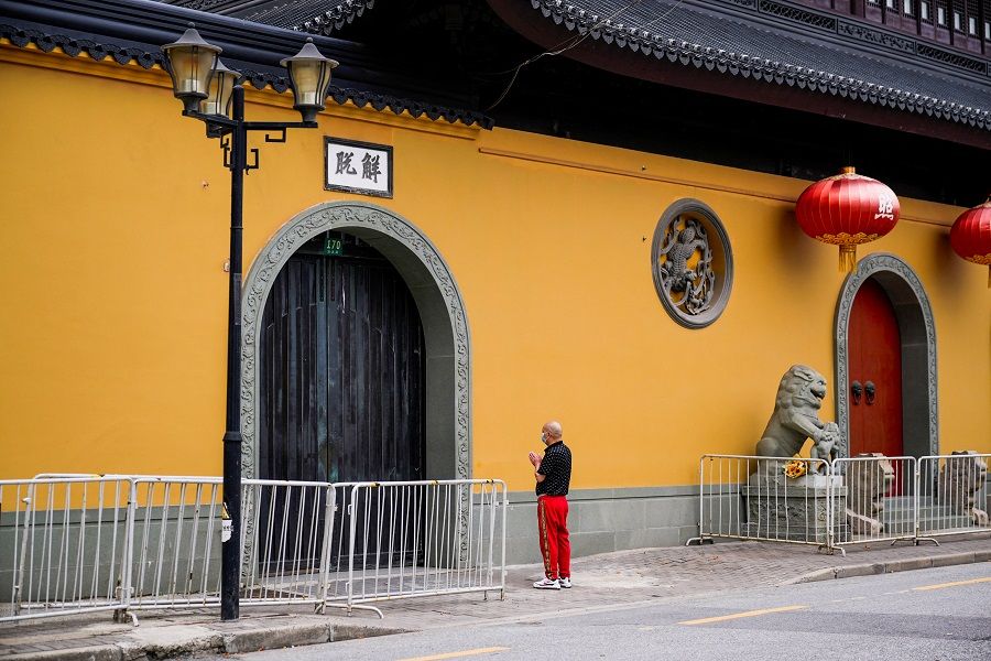 A man prays outside a closed temple during lockdown, amid the Covid-19 outbreak, in Shanghai, China, 30 May 2022. (Aly Song/Reuters)