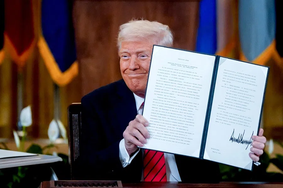 US President Donald Trump displays a signed executive order in the East Room of the White House in Washington, DC, US, on 20 March 2025.