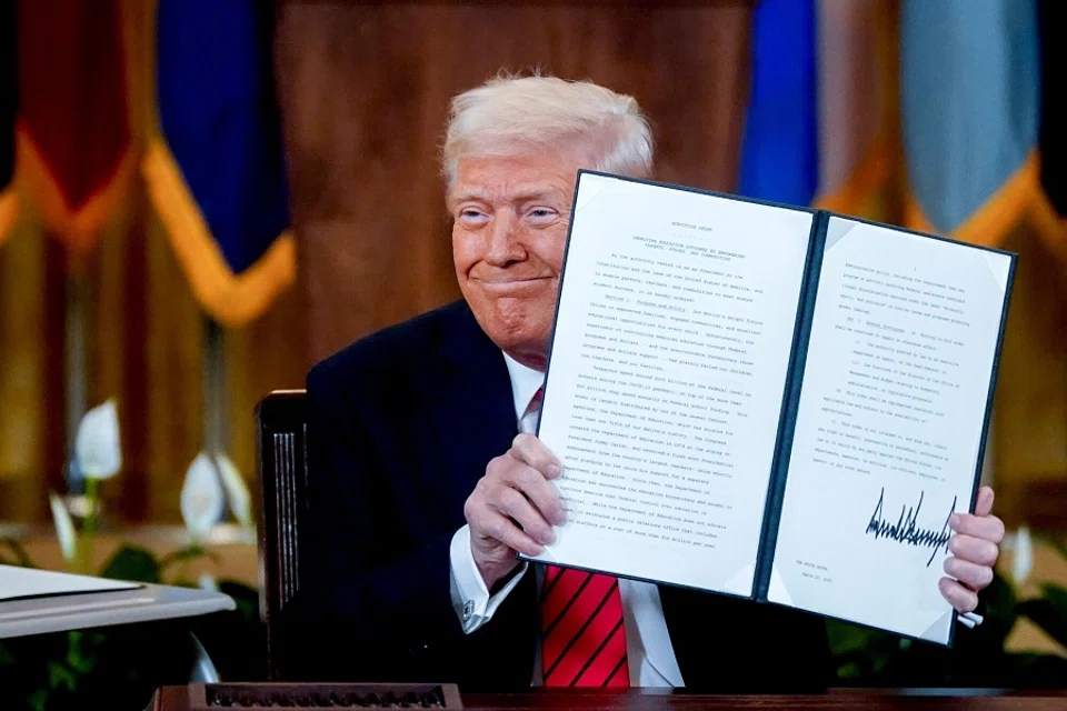 US President Donald Trump displays a signed executive order in the East Room of the White House in Washington, DC, US, on 20 March 2025. (Kent Nishimura/Bloomberg)