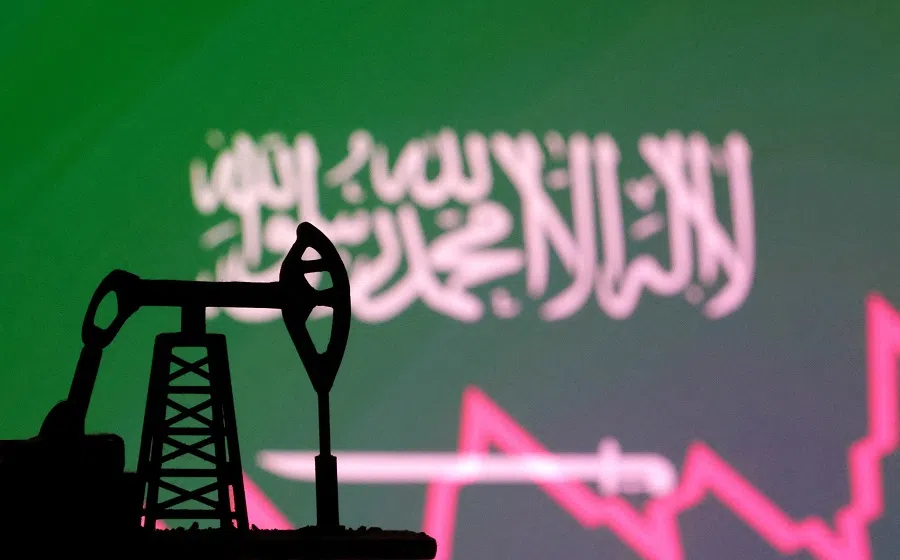 Saudi Arabian flag with stock graph and an oil pump jack miniature model are seen in this illustration taken on 9 October 2023.