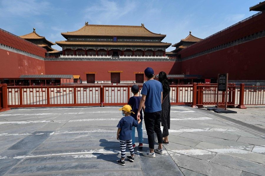 A family looks at the Forbidden City closed due to Covid-19 outbreak in Beijing on 17 May 2022. (Wang Zhao/AFP)