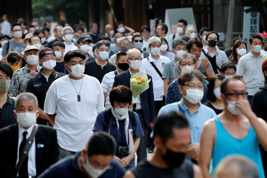 People wearing protective face masks pay tribute to the war dead at Yasukuni Shrine on the 75th anniversary of Japan's surrender in World War Two, amid the coronavirus disease (Covid-19) pandemic, in Tokyo, 15 August 2020. (Kim Kyung-Hoon/REUTERS)