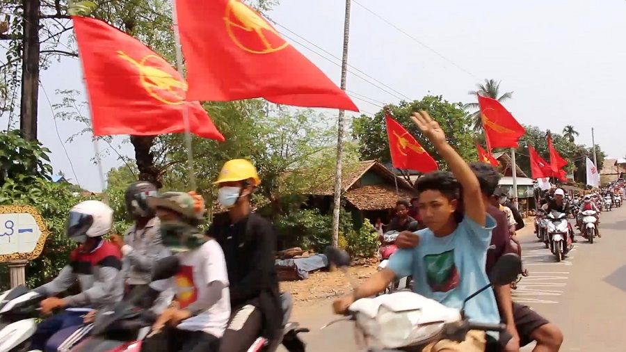 Protesters fly the flags of the National League for Democracy (NLD) as they ride their motorcycles in Dawei district, Myanmar, 16 March 2021, in this still image obtained from a video. (Courtesy of Dawei Watch via Reuters)