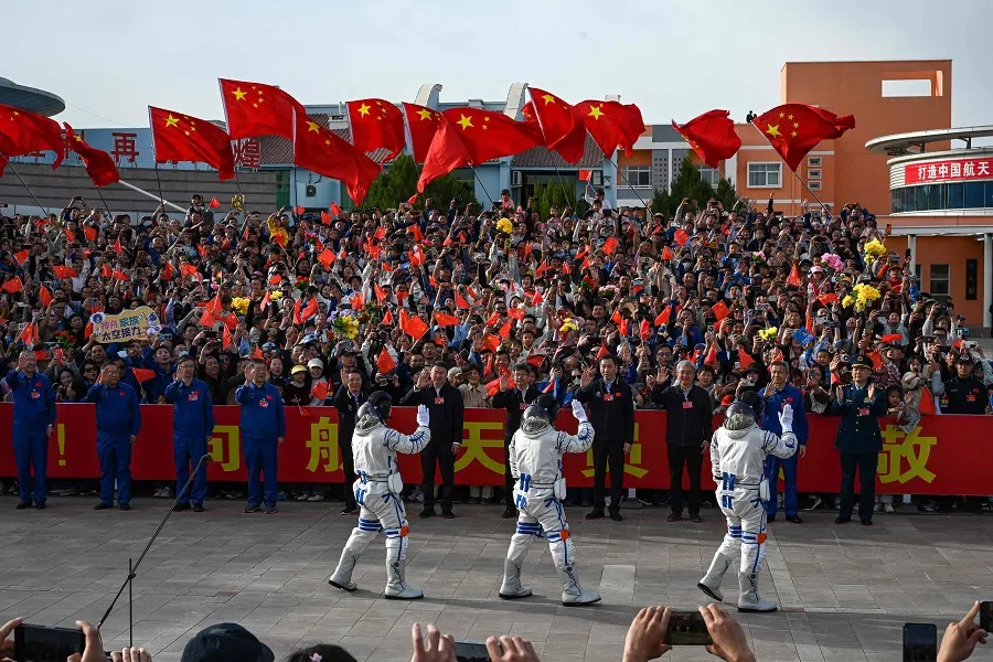  Astronauts for China’s Shenzhou-18 space mission wave during a departure ceremony before boarding a bus to take them to the Shenzhou-18 spacecraft at the Jiuquan Satellite Launch Centre in the Gobi desert in northwest China on 25 April 2024.  (Greg Baker/AFP)