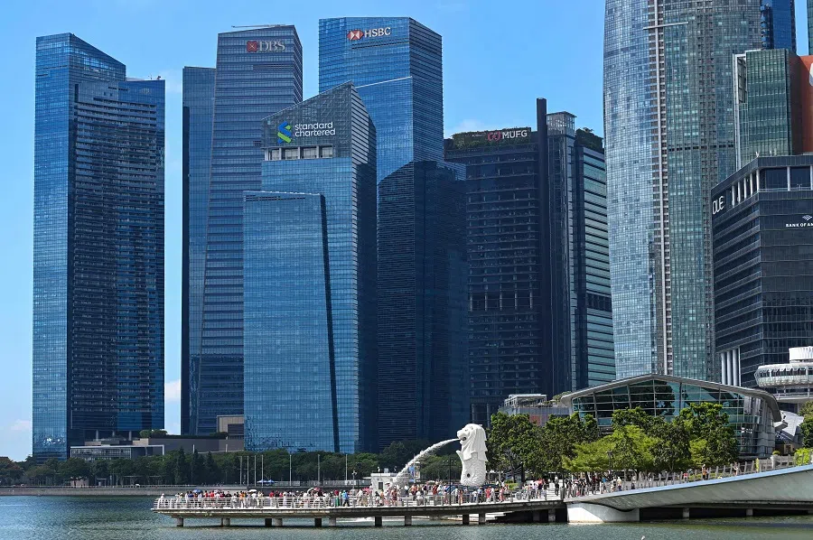 People gather for photographs next to the Merlion statue at Marina bay waterfront in Singapore on 18 March 2024. (Roslan Rahman/AFP)