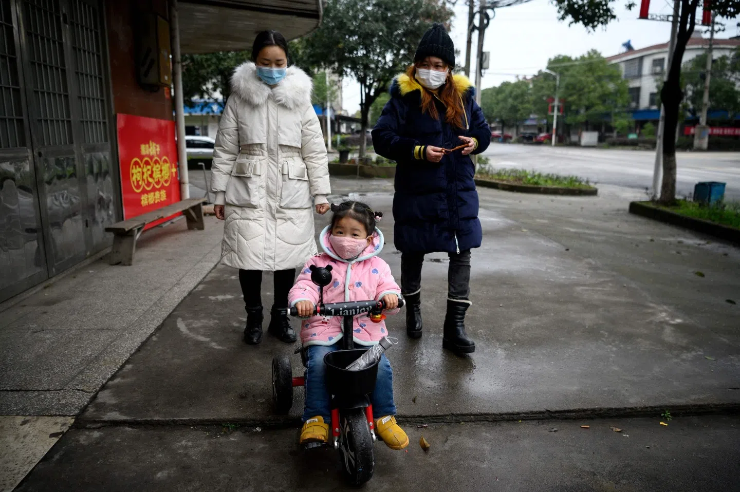 People wearing face masks walk along a street in Yueyang, Hunan province on 3 March 2020. (Noel Celis/AFP)