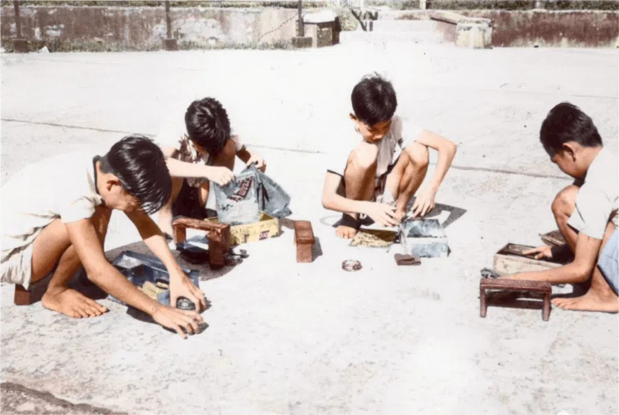 In the 1950s, a group of shoeshine boys organise their tools by the roadside. Poverty in the family often led to insufficient education for the next generation, making it easy for the cycle of poverty to continue.