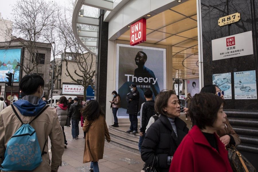 Pedestrians walk past a Uniqlo store in Shanghai, China, on 26 March 2021. Japanese brands Muji and Uniqlo became the latest to be embroiled in the escalating controversy over cotton sourced from China's Xinjiang region. (Qilai Shen/Bloomberg)