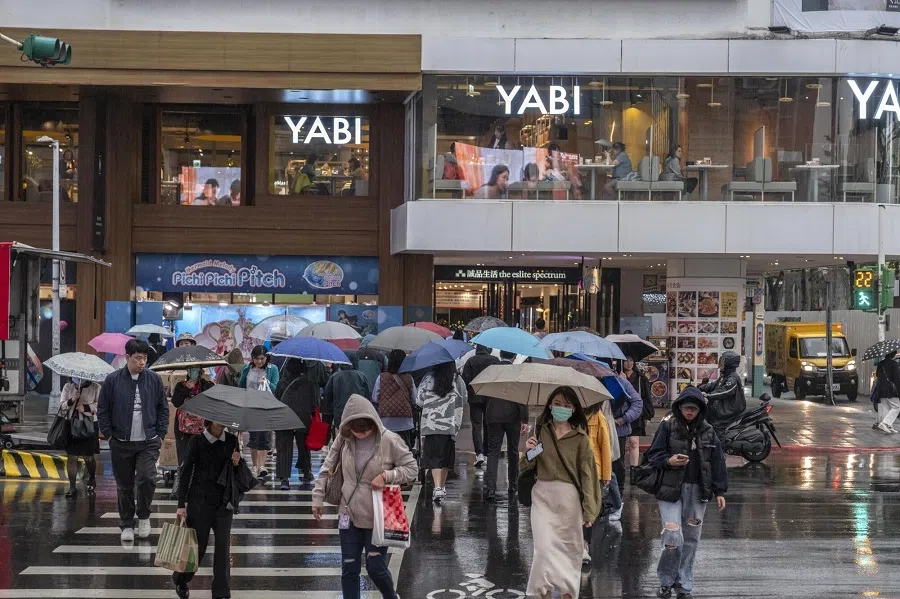 People cross a street in Taipei, Taiwan, on 6 December 2023. (Lam Yik Fei/Bloomberg)