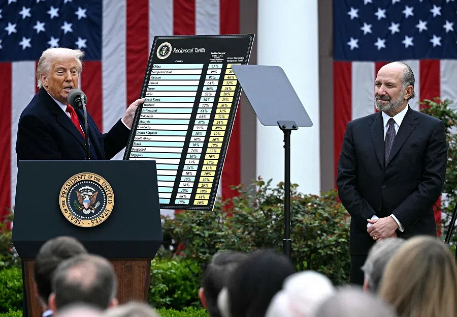 US President Donald Trump holds a chart as he delivers remarks on reciprocal tariffs alongside US Secretary of Commerce Howard Lutnick during an event in the Rose Garden entitled “Make America Wealthy Again” at the White House in Washington, DC, US, on 2 April 2025. (Brendan Smialowski/AFP)