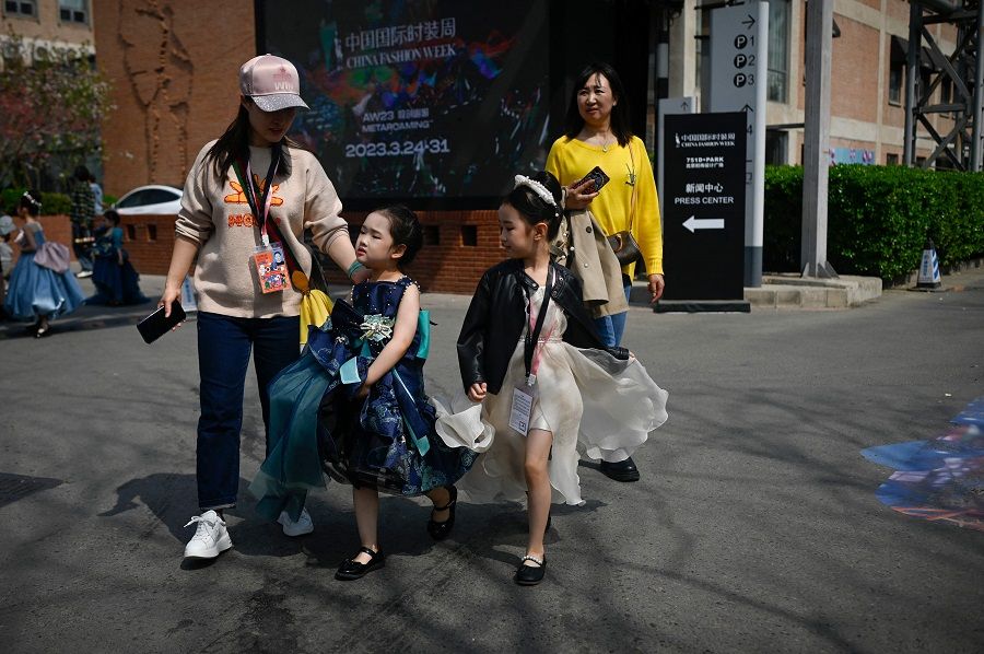 Two young models walk along a road during the China Fashion Week in Beijing, China, on 31 March 2023. (Wang Zhao/AFP)