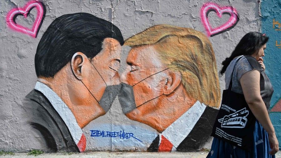 A mural painting by graffiti artist Eme Freethinker features likenesses of US President Donald Trump (R) and Chinese premier Xi Jinping wearing face covers in Berlin, 28 April 2020. (John MacDougall/AFP)