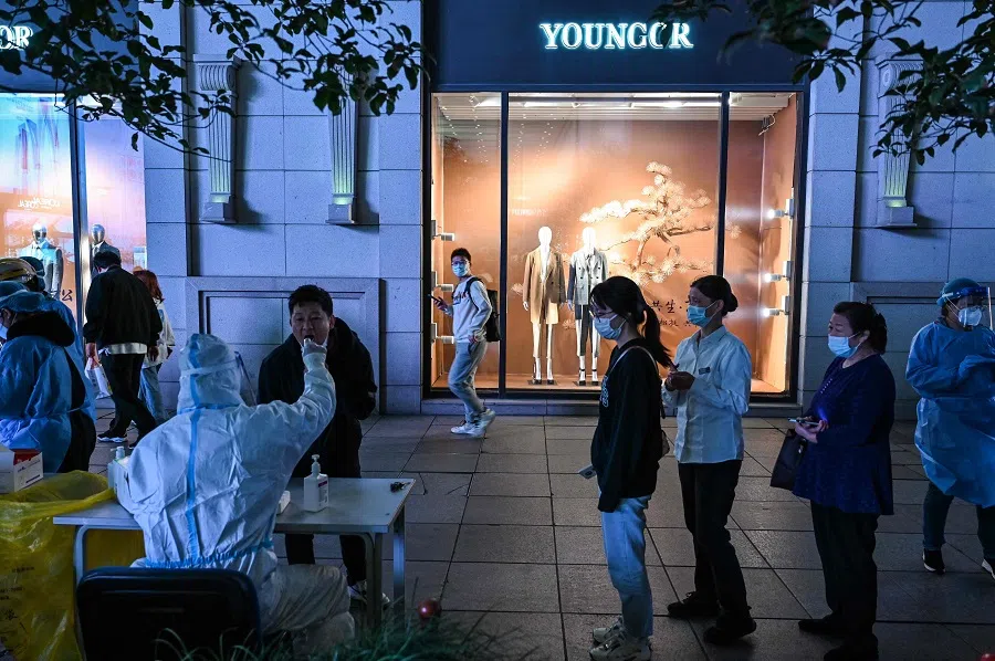 A health worker takes a swab sample from a man to be tested for Covid-19 in Huangpu district in Shanghai, China, on 24 October 2022. (Hector Retamal/AFP)