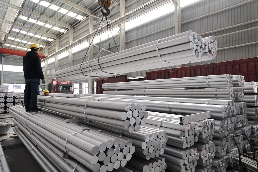 This picture taken on 24 February 2025 shows a worker loading alumium rods at an aluminium-base material factory in Binzhou, in eastern China’s Shandong province. (AFP)