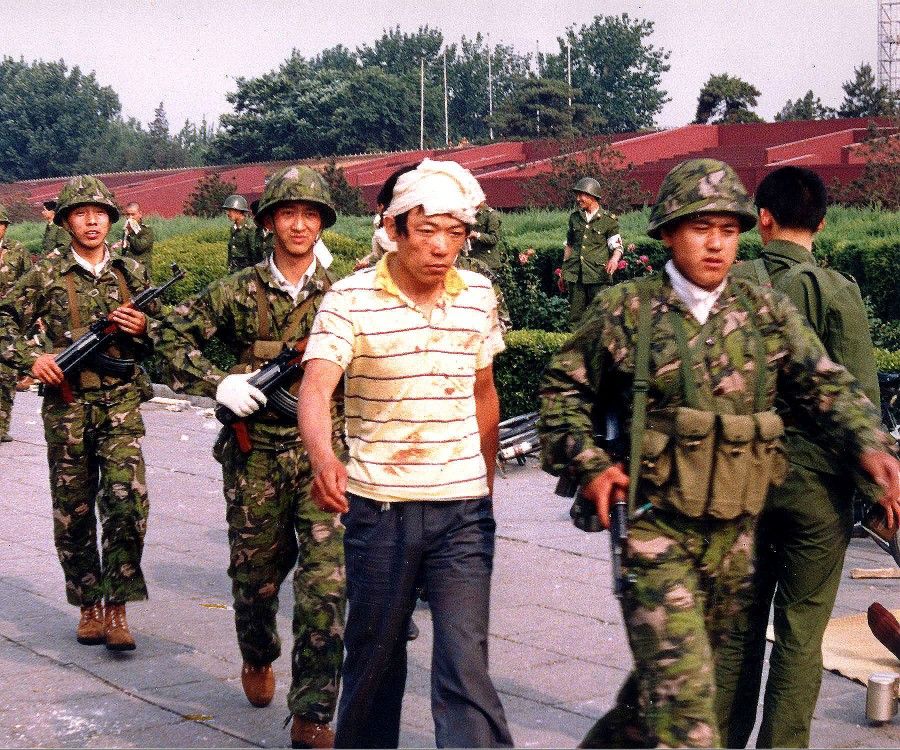 The People's Liberation Army escorts an injured civilian during the Tiananmen Square protests.
