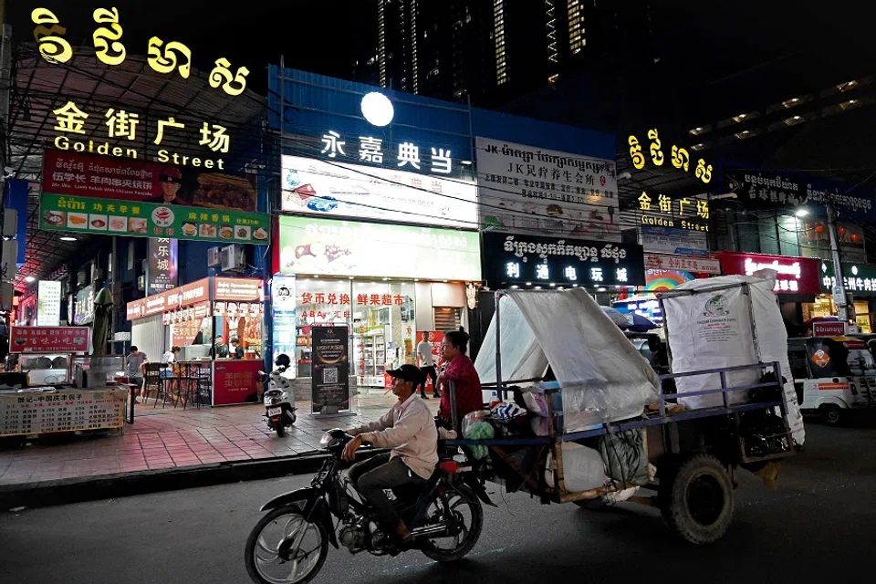 A man rides a cart past chinese shops and restaurants in Phnom Penh, Cambodia on 15 September 2023. (Tang Chhin Sothy/AFP)