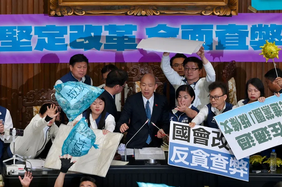Lawmakers from main opposition Kuomintang stop garbage bags thrown by ruling Democratic Progressive Party legislators to hit Parliament Speaker Han Kuo-yu (centre) during voting for the Parliament reform bill in Taipei, Taiwan, on 28 May 2024. (Sam Yeh/AFP)