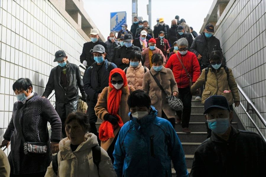 People walk through an underpass in Beijing on 22 March 2023. (Wang Zhao/AFP)