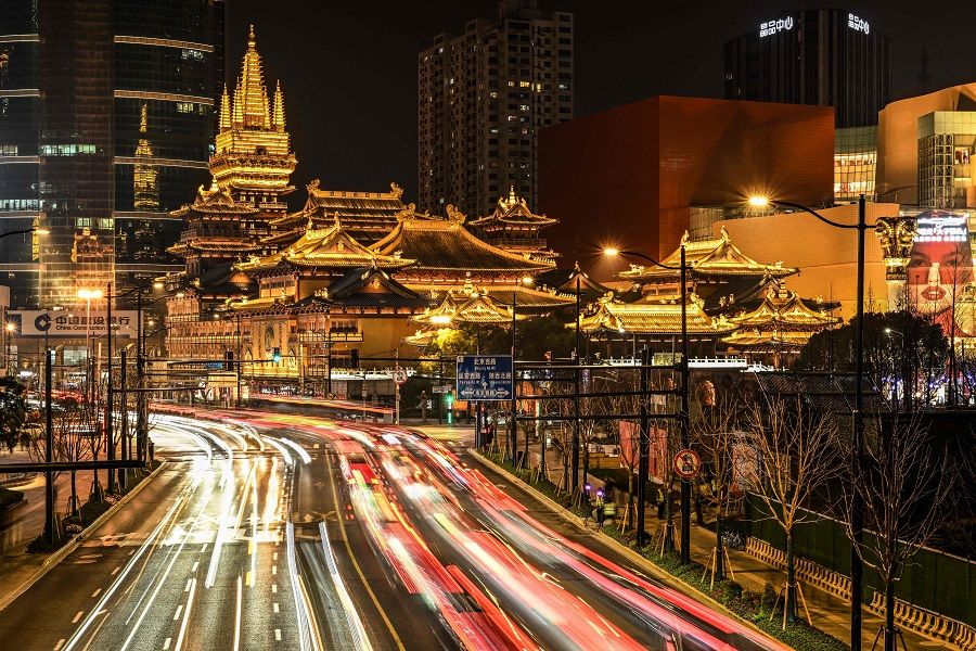 This long exposure picture shows traffic along a road leading to the Jing'an Temple in Shanghai on 9 March 2024. (Hector Retamal/AFP)