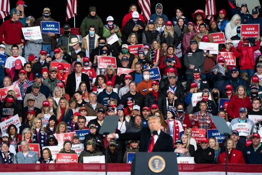Attendees listen as US President Donald Trump speaks during a rally in Valdosta, Georgia, US, on Saturday, 5 December 2020. Trump berated Georgia's Republican governor before heading to the state to campaign for two key Senate candidates, keeping up attacks that party leaders worry could backfire. (Elijah Nouvelage/Bloomberg)
