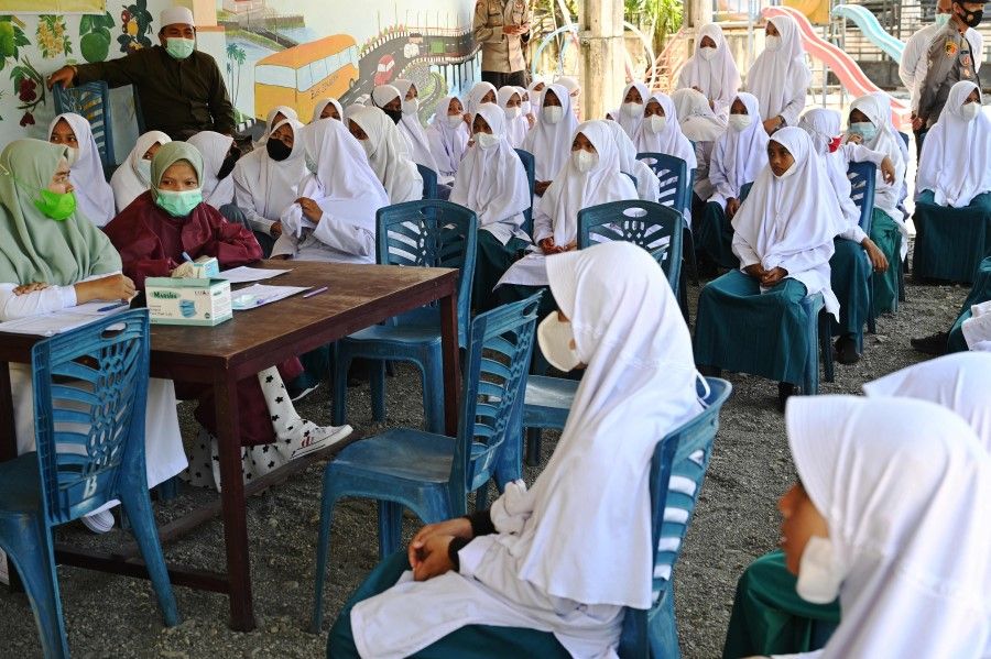 Students wait to receive the Sinovac Covid-19 coronavirus vaccine at a school in Meulaboh, Aceh province on 6 September 2021. (Chaideer Mahyuddin/AFP)